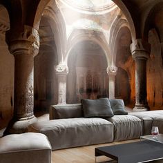 a living room filled with lots of furniture next to an arched ceiling covered in stone