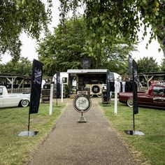 an outdoor area with several cars parked in the background and people walking around it on either side