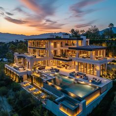 an aerial view of a modern home at dusk with lights on the pool and patio