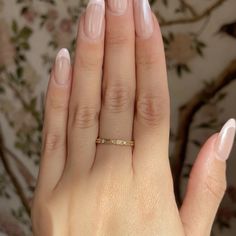 a woman's hand with pink manies and a gold ring on it,