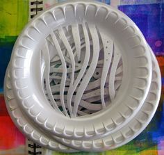 two white plates sitting next to each other on top of a colorful cloth covered table