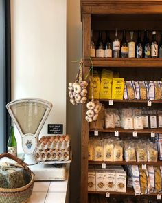 an assortment of food items displayed on shelves in a store with a coffee grinder next to it