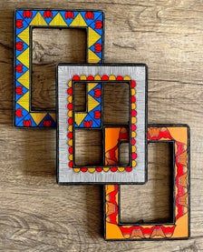 two colorful wooden frames sitting on top of a wooden table