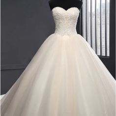 a wedding dress on display in front of a window