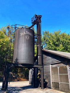 an old grain silo in front of a building with trees and blue sky behind it