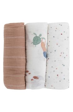 three baby swaddles are lined up in different colors and designs, one with a turtle on it