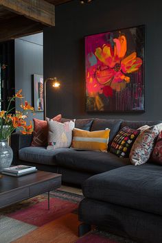 a living room filled with lots of furniture next to a large painting on the wall