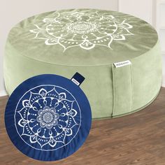 a round ottoman with a blue and white flower design on the top, sitting on a wooden floor