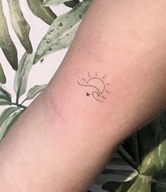 a woman's arm with a small sun tattoo on the left side of her arm