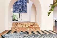 a blue and white rug sitting on top of a wooden floor next to a doorway