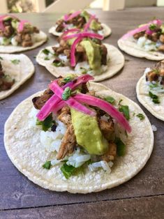 several tortillas with meat, onions and avocado