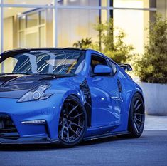 a blue sports car parked in front of a building