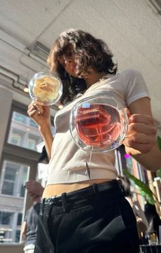 a woman is holding two wine glasses in her hands