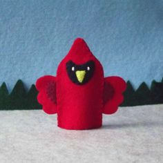 a red bird with black eyes and yellow beak