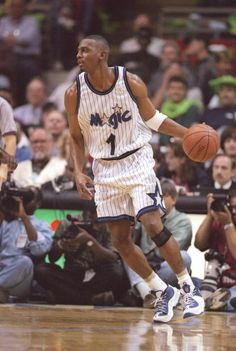 a basketball player dribbling the ball during a game with an audience watching him