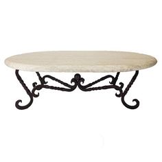 a white marble top coffee table with wrought iron legs and an ornate design on the base