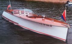 a small wooden boat in the water with an american flag on it's side