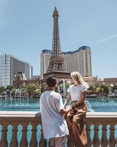 a man and woman looking at the eiffel tower