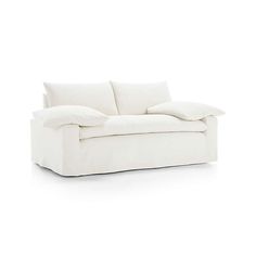 a white couch with two pillows on it's back and one arm facing the camera