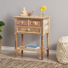 a wooden table with two drawers sitting on top of it next to a potted plant