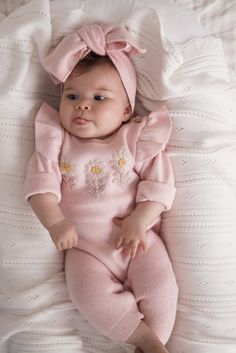 Watch your little girl blossom and bloom in our Daisy Jumpsuit. This pretty in pink ensemble is a beautiful dusty rose, perfect for your little flower. The jumpsuit is decorated with three embroidered daisies on the front for extra cute character, and ruffle details on the sleeves that will look like little petals on your little one's shoulders. The look is completed with a matching headband tied on top with a bow. The headband of this garment is shipped untied in order to allow you to adjust yo Newborn Girl Winter Outfits, Daisy Jumpsuit, Pink Baby Clothes, Embroidered Daisies, Ella Bella, French Baby, Diaper Bag Accessories, Autumn Rose, Baby Basics