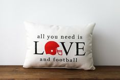 a pillow that says, all you need is love and football on the front with an image of a helmet