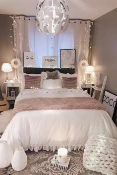 a white bed sitting under a chandelier in a bedroom