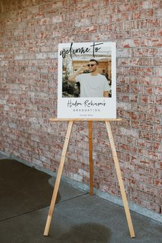 a wooden easel with a sign on it that says welcome to jordan robinson and is standing in front of a brick wall