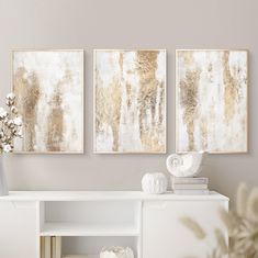 two paintings on the wall above a white shelf with books and vases in front of it