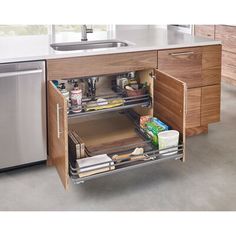 an open drawer in a kitchen next to a dishwasher