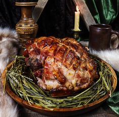 a ham is sitting on a platter with some green grass in front of it