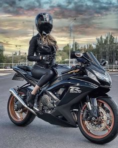 a woman sitting on top of a black motorcycle