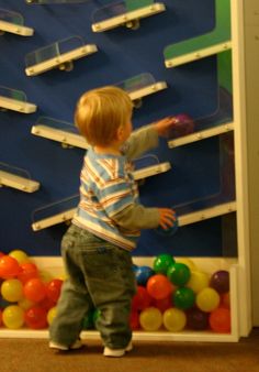 a young boy standing in front of a display of balloons