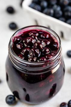 a jar filled with blueberries sitting on top of a table