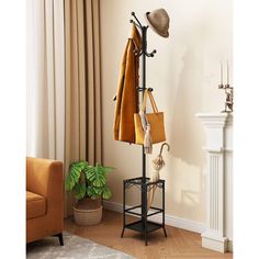 a coat rack with umbrellas and hats on it next to a chair in a living room