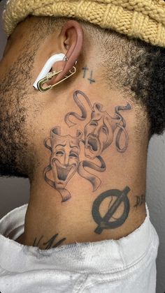 the back of a man's neck with tattoos on it and an ear piercing