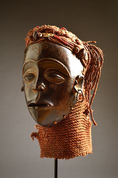 an african mask with braids on it's head