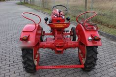 a red tractor parked on the side of a road