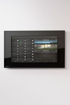 a wall mounted video player on the side of a white wall next to a black framed object