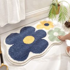 a bathroom rug with blue and yellow flowers on it