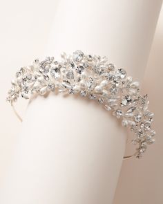 a close up of a bracelet on a white mannequin headband with pearls and crystals