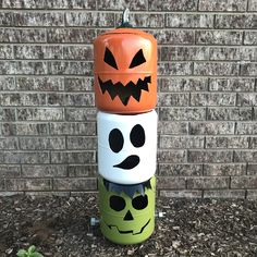 three halloween containers stacked on top of each other in front of a brick wall with pumpkins