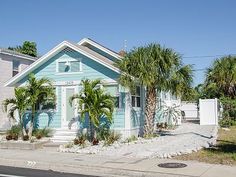 a blue house with palm trees in front of it