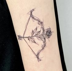 an arrow and flower tattoo on the arm