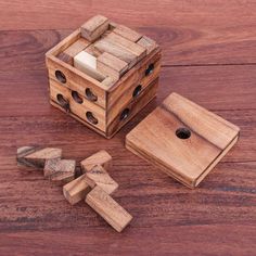 a wooden puzzle with pieces missing from it on a wood floor, next to a piece of wood that has been cut in half