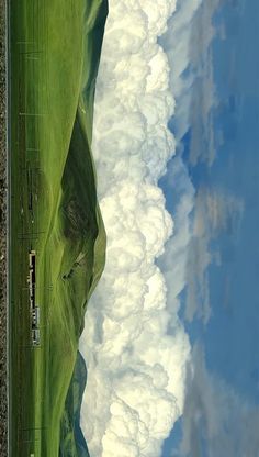 an aerial view of clouds and grass in the sky