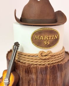 a cake with a hat, guitar and name on it