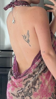 a woman with a bird tattoo on her back