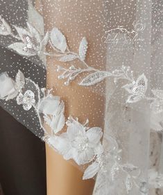 a white veil with flowers and pearls on it