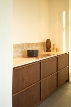 an empty kitchen with wooden cabinets and counter tops, including a black bowl on the counter